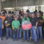 Welding students hold "Thank you" sign